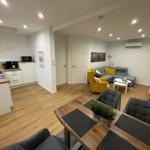 Wohnung mit Küche, Essbereich und Wohnzimmer mit Sofa und Stühlen.