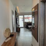 Hallenraum mit Holzmöbeln und Blick ins Wohnzimmer.