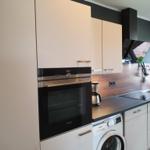 Moderne Küche mit integriertem Backofen und Spülmaschine.