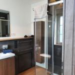 Badezimmer mit Dusche, Waschbecken und Spiegel