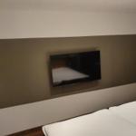 Schlafzimmer mit Bett und Wandfernseher