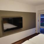 Schlafzimmer mit Fernseher und Blick auf Garten