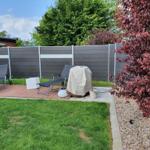 Hinterhof mit Garten, Terrasse und Liegestühlen. Grill und Pflanzen sind vorhanden.