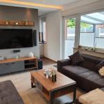 Wohnzimmer mit Sofa, Couchtisch und Fernseher an der Wand.