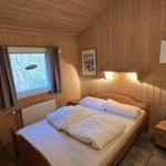 Schlafzimmer mit Holzwand, Bett, Fenster und Spiegeln.