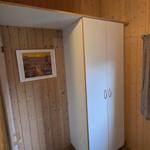 Schlafzimmer mit Kleiderschrank, Fenster und Wandbild.