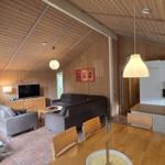 Wohnküche mit Holzdecke, Sofa, Esstisch und Küchenspüle