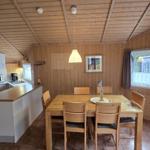 Küche und Essbereich mit Holzwänden und -decke. Esstisch mit sechs Stühlen.