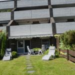 Garten mit Liegestühlen und Terrasse vor Mehrfamilienhaus