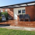 Terrasse mit Sitzgruppe, Sonnenschutz und Gartenbereich.