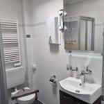 Badezimmer mit Dusche, Toilette und Waschbecken.