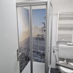 Duschkabine mit Blick auf Landschaft, Toilette und Heizkörper