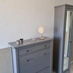 Schmucktisch mit Pflanzen und Dekorationsgegenständen neben einem Spiegelschrank.