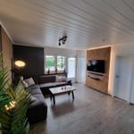 Wohnzimmer mit Sofa, Fernseher und Holzboden.