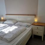 Ein Bett mit weißen Bettwäsche und zwei Nachttischen mit Lampen.