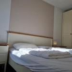 Schlafzimmer mit Bett, Nachttisch und Kleiderschrank.