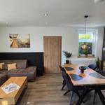 Wohn- und Essbereich mit Sofa, Tisch und Wanddekoration.