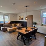 Wohn- und Essbereich mit Sofa, Esstisch und Blick auf Garten