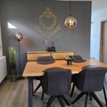 Esstisch mit vier Stühlen vor einer Wand mit Ankerdekoration.