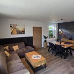 Wohn- und Essbereich mit Sofa, Esstisch und Wanddekoration.