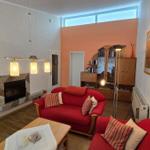 Wohnzimmer mit rotem Sofa, Kamin und Holzboden.