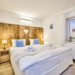 Schlafzimmer mit Holzbett, Fenster und Strandbild.