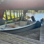 Ein Motorboot steht auf einem Holzsteg unter einem roten Dach.