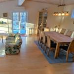 Wohn- und Essbereich mit Holzboden, Sofa, Esstisch und Fenster.