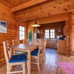 Esszimmer mit Holztisch, Stühlen und Blick in die Küche