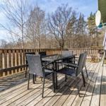 Holzterrasse mit Sitzgruppe und Blick in den Wald.