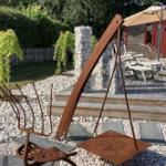 Hinterhof mit Holzterrasse, Sonnenschirm und rustikalem Gartenmöbel.