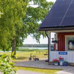 Rezeptionshaus mit Solarpaneelen und Blick auf einen See.