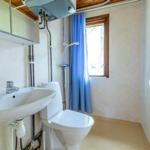 Badezimmer mit Toilette, Waschbecken und Dusche mit blauer Vorhang.