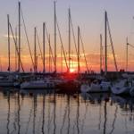 Sonnenuntergang über einem Hafen mit ankern und Segelyachten.
