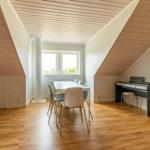 Dieser Raum hat Holzdecke, Parkettboden und ein digitales Keyboard.