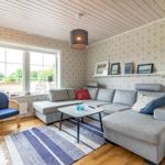 Wohnzimmer mit grauem Sofa, blauem Sessel und gemusterten Wänden.