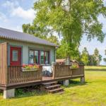 Haus mit Holzterrasse, Garten und Blick auf Wald.