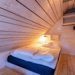 Schlafzimmer mit Holzwand, Bett und Kleiderständer