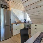 Küche mit Kühlschrank, Herd und Essbereich unter Holzdach