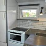 Küche mit Kühlschrank, Herd und Fenster