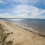 Strand mit Wohnwagen und Meer im Hintergrund