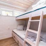 Zimmer mit Doppelstockbett, Holzwand und Fenster