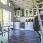 Küche mit Essbereich, Fenster, Kamin und Treppe zur oberen Etage.