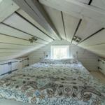 Schlafzimmer mit Dachschrägen, Bett und Fenster.
