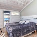 Schlafzimmer mit Bett, Nachttisch und Tür zum Balkon.