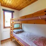 Ein Schlafzimmer mit einem Holzbett und einem Fenster.