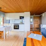 Küche, Essbereich und Wohnzimmer mit Holzboden und -decke.