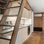Küche mit Holztreppenstufe und Küchenzeile.