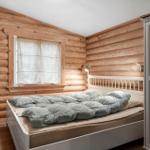 Schlafzimmer mit Holzwand, Bett, Stuhl und Kleiderschrank.