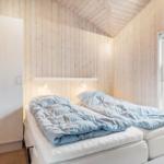 Bedroom with double bed, wooden walls, and window.